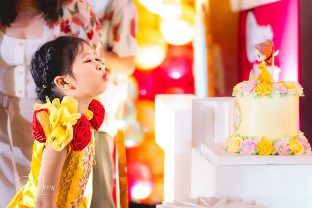 Themed birthday set-up with a balloon arch and castle backdrop inside an air-conditioned hall